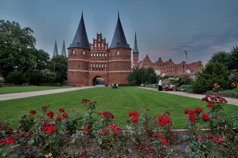Das Holstentor in Lübeck mit blühenden Rosen davor